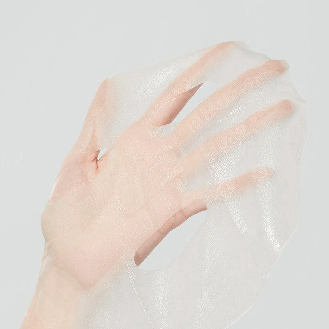 Creamy, high-density white peptide fluid saturating an ultra-adherent microfiber sheet texture of Medicube Deep Peptide Mask at Atelier De Glow UK.