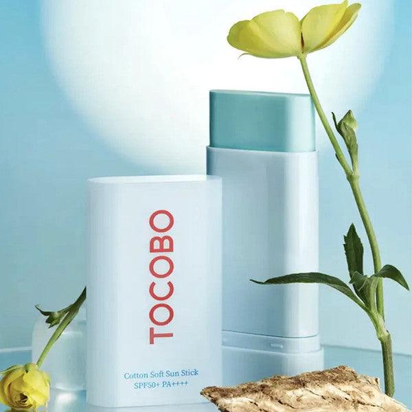 Sky-blue, solid, and ultra-silky micro-powder texture of TOCOBO Cotton Sun Stick gliding seamlessly over a facial canvas at Atelier De Glow UK.